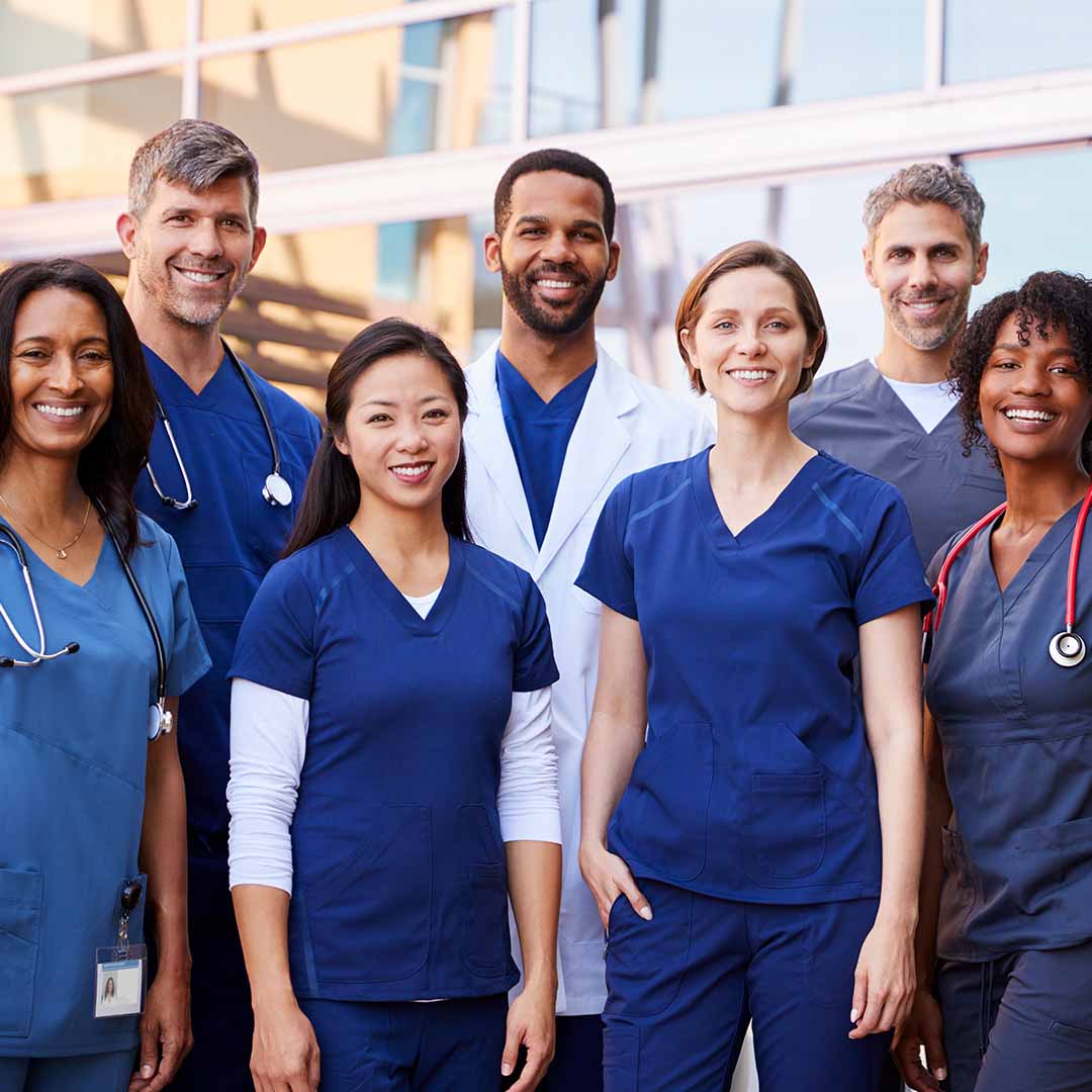A group of mixed-race doctors smiling at the camera