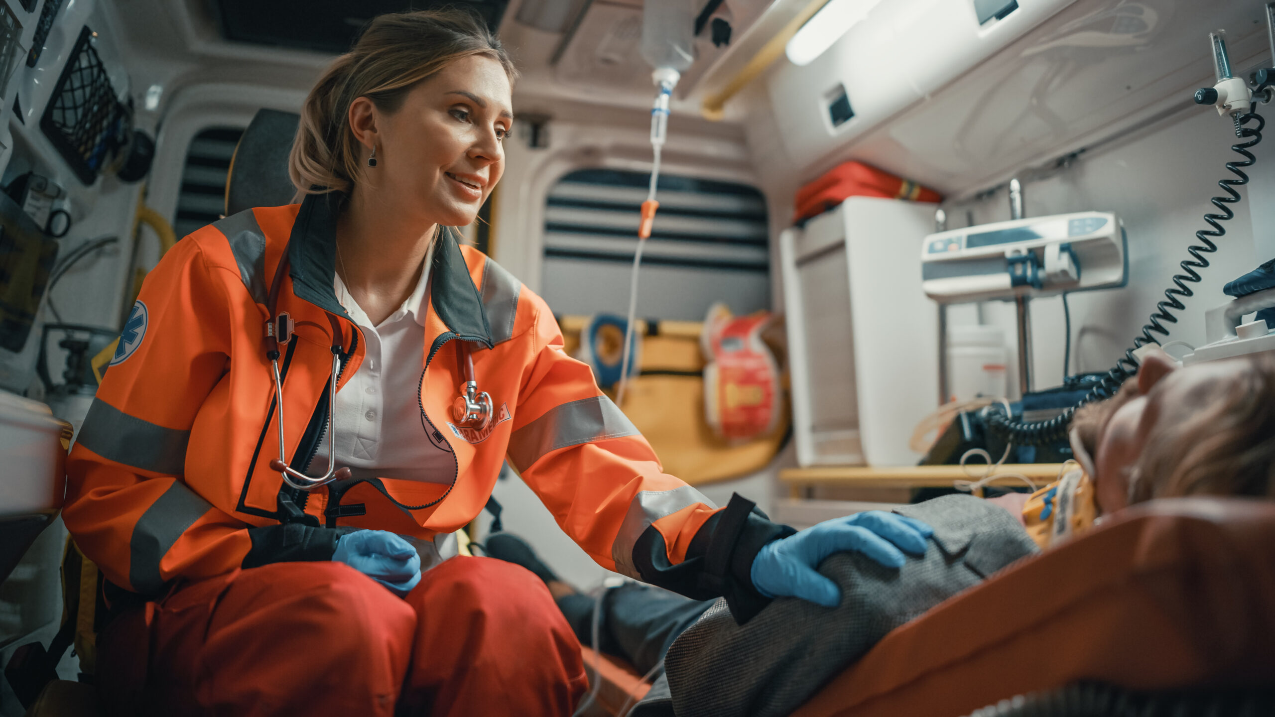 Portrait of a female EMS paramedic standing in front of Camera in high visibility medical orange uniform